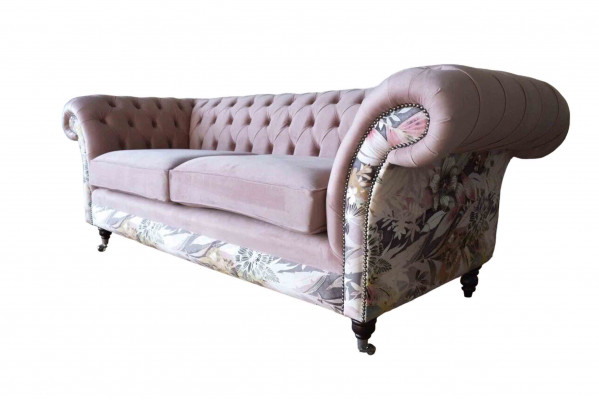 A vibrant three-seater Chesterfield sofa with a delicate pink floral pattern