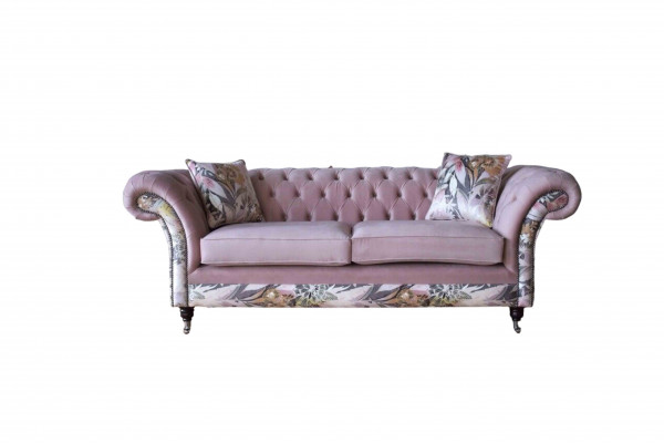 A vibrant three-seater Chesterfield sofa with a delicate pink floral pattern